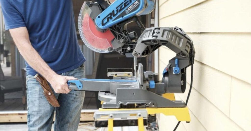 man in blue shirt adjusts type of miter saw